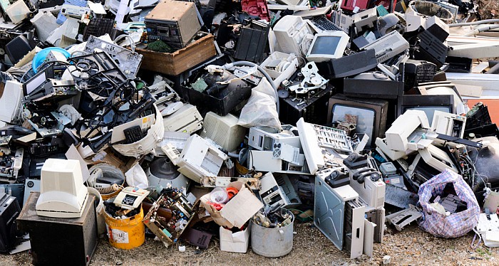 A landfill site with computers, monitors and bags of rubbish.